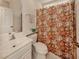 Clean bathroom with a toilet, sink, and floral shower curtain at 444 Pinewood Lake Dr, Venice, FL 34285