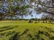 Peaceful golf course view with large trees and a clear sky at 444 Pinewood Lake Dr, Venice, FL 34285