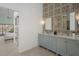 Double vanity bathroom with marble countertops and gray cabinets at 5003 Southern Pine Cir, Venice, FL 34293