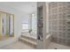 Spa-like bathroom with a soaking tub, glass-block window, and patterned tile at 5003 Southern Pine Cir, Venice, FL 34293