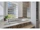 Bathroom features a soaking tub, glass block window and patterned tile shower at 5003 Southern Pine Cir, Venice, FL 34293