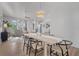 Dining area with modern chandelier, light wood table, and black chairs at 5003 Southern Pine Cir, Venice, FL 34293