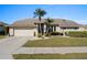 Tan house with palm trees, a large driveway, and well-maintained landscaping at 5003 Southern Pine Cir, Venice, FL 34293