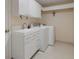 Bright laundry room with washer, dryer, and modern white cabinets at 5003 Southern Pine Cir, Venice, FL 34293