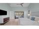 Main bedroom with a king bed, pool view, and large TV at 5003 Southern Pine Cir, Venice, FL 34293