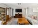 Living room with hardwood floors, sofas, a large TV, and built-in shelving at 5172 Rolla Rd, Venice, FL 34293