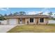 Tan house with white garage door and landscaping at 5296 Rolla Rd, Venice, FL 34293