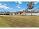 Single-story home exterior with a spacious lawn and palm trees at 5296 Rolla Rd, Venice, FL 34293