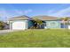 Beautiful teal house with a white garage door and manicured lawn at 5298 Drew Rd, Venice, FL 34293