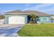 Curb appeal! Teal home with white garage door and lush lawn at 5298 Drew Rd, Venice, FL 34293