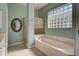 Bathroom with bathtub, shower, and glass block window at 589 Pond Willow Ln, Venice, FL 34292