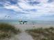 Peaceful beach scene with umbrellas and calm ocean waters at 589 Pond Willow Ln, Venice, FL 34292