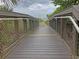 Boardwalk path leading to beach with railings and yellow stripe at 589 Pond Willow Ln, Venice, FL 34292