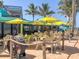 Outdoor patio dining area with tables, umbrellas, and ocean views at 589 Pond Willow Ln, Venice, FL 34292