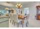 Elegant dining room with a large table, chandelier, and neutral color palette at 589 Pond Willow Ln, Venice, FL 34292