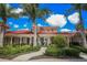 Community clubhouse entrance with lush landscaping and walkway at 589 Pond Willow Ln, Venice, FL 34292