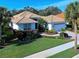 Single-story home with tile roof, landscaped yard, and two-car garage at 589 Pond Willow Ln, Venice, FL 34292