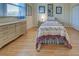 Bright bedroom with light wood floors, a double bed, and a dresser at 746 Fringed Orchid Trl, Venice, FL 34293