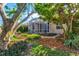 Landscaped backyard featuring a screened enclosure and mature trees at 121 Amora Ave, Venice, FL 34285