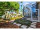 Screened patio and backyard with stone pathways and tropical plants at 121 Amora Ave, Venice, FL 34285