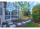 Landscaped backyard with screened porch and walkway at 121 Amora Ave, Venice, FL 34285