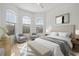 Bright bedroom with large windows, plush bed, and two accent chairs at 121 Amora Ave, Venice, FL 34285