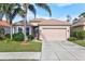 Well maintained tan house with palm trees and a two-car garage at 121 Amora Ave, Venice, FL 34285