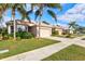 Houses with tan exteriors, palm trees, and landscaped yards at 121 Amora Ave, Venice, FL 34285