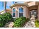 Front entry with double doors, landscaping, and stone accents at 121 Amora Ave, Venice, FL 34285