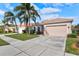 Single-Gathering house with a two-car garage and palm trees at 121 Amora Ave, Venice, FL 34285