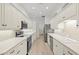 Long kitchen with white cabinets and stainless steel appliances at 121 Amora Ave, Venice, FL 34285