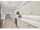 White kitchen with stainless steel appliances and tile flooring at 121 Amora Ave, Venice, FL 34285