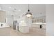 Open kitchen boasts white cabinets, stainless steel appliances, and hardwood floors at 121 Amora Ave, Venice, FL 34285