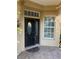 Front entry with dark brown door and sidelights, tile flooring, and storm door at 125 Amora Ave, Venice, FL 34285