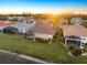 Aerial view of a community with houses, landscape, and sunset at 1307 Highland Greens Dr, Venice, FL 34285