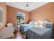 Bedroom with two twin beds, a wicker chair, and large window at 1307 Highland Greens Dr, Venice, FL 34285