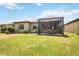 House with a screened patio and a spacious grassy backyard at 13510 Esposito St, Venice, FL 34293