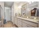 Double vanity bathroom with granite countertop and large mirrors at 13510 Esposito St, Venice, FL 34293