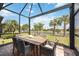 Screened patio with table and chairs, offering a tranquil water view at 13510 Esposito St, Venice, FL 34293