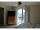 Bedroom with dresser, TV, and sliding door to balcony at 1739 Bonitas Cir # 1724C, Venice, FL 34293