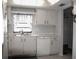 Small kitchen with white cabinets, dishwasher, and double sink at 1739 Bonitas Cir # 1724C, Venice, FL 34293