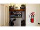 Small storage closet with various items, fire extinguisher, and shelving at 1739 Bonitas Cir # 1724C, Venice, FL 34293