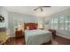Light and airy bedroom with a queen-size bed, wood floors and plantation shutters at 21042 Anclote Ct, Venice, FL 34293