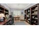 Home office with built-in bookshelves, desk, and comfortable chair at 21042 Anclote Ct, Venice, FL 34293