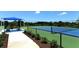 Well-maintained tennis court with a shaded seating area at 21042 Anclote Ct, Venice, FL 34293