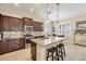 Modern kitchen with granite island, dark cabinets, and stainless steel appliances at 21208 Sandal Foot Dr, Venice, FL 34293