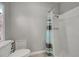 This is a bathroom with a shower with a grey and white striped curtain, a white toilet, and beige tile floors at 215 Portia N St, Nokomis, FL 34275
