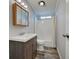 Traditional bathroom featuring a dark vanity with a white basin, a shower-tub combo and brown patterned tile floors at 215 Portia N St, Nokomis, FL 34275