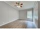 This is a light grey bedroom with wood floors, a window, a ceiling fan, and a large closet at 215 Portia N St, Nokomis, FL 34275