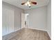 Bedroom with neutral gray walls, wood floors, closet, ceiling fan and adjacent bathroom for a private retreat at 215 Portia N St, Nokomis, FL 34275